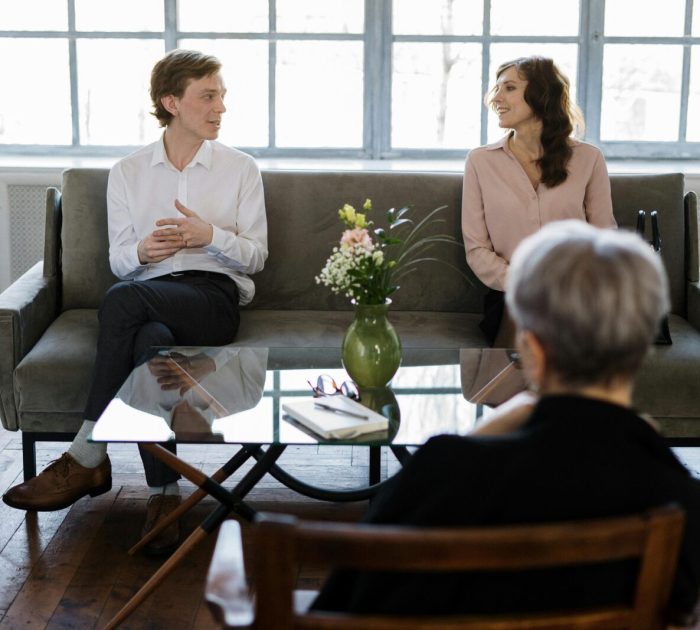Couple engaged in a therapy session with a counselor in a loft setting.